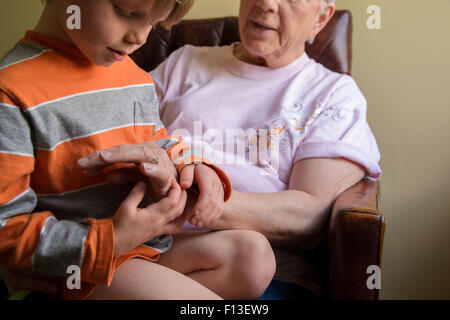 Nahaufnahme eines jungen auf seiner Großmutter Schoß Stockfoto