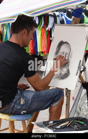 Street artist skizzieren Zeichnen mit Aufsteller Stockfoto