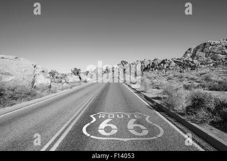 Joshua Tree Highway mit Route 66 Pflaster Schild in schwarz und weiß. Stockfoto