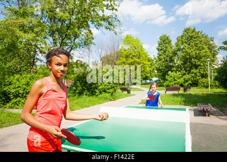 Zwei Mädchen spielen Ping-Pong draußen im Sommer Stockfoto