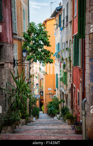 VILLEFRANCHE-SUR-MER, Frankreich-4. Oktober 2014: Schmale Straße mit bunten alten Gebäuden führt hinunter Mittelmeer Meer im Mittelmeer Stockfoto