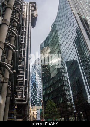 Stürmisch und sonnigen Slkies leuchten die Gurke und die Lloyds-Gebäude in der City of London und St Undershaft Kirche Stockfoto