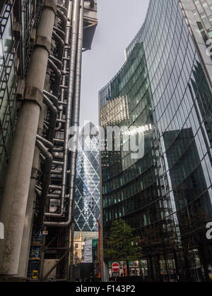 Stürmisch und sonnigen Slkies leuchten die Gurke und die Lloyds-Gebäude in der City of London und St Undershaft Kirche Stockfoto