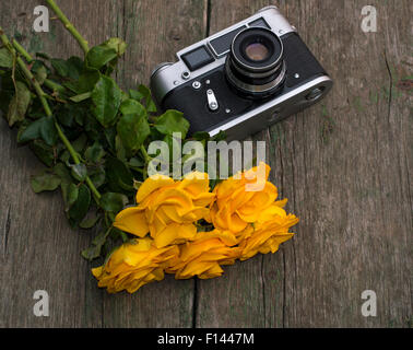 Bouquet von gelben Rosen und Retro-die Kamera auf einem Tisch Stockfoto