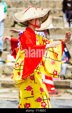 Japan, Tsuyama. Frühling Cherry Blossom Festival in Kakuzan Park. Kind in der Linie, das Tragen von Tradition yukata Jacke tragen und Strohhut, tanzen. Stockfoto