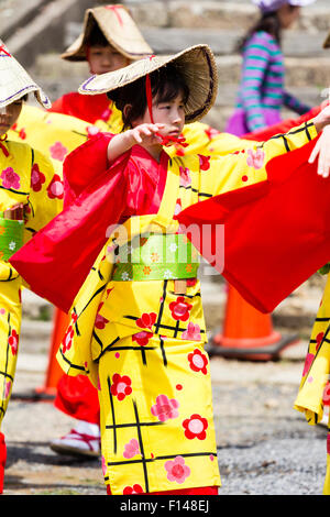 Japan, Tsuyama. Frühling Cherry Blossom Festival in Kakuzan Park. Kind in der Linie, das Tragen von Tradition yukata Jacke tragen und Strohhut, tanzen. Stockfoto