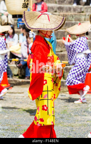 Japan, Tsuyama. Frühling Cherry Blossom Festival in Kakuzan Park. Kind in der Linie, das Tragen von Tradition yukata Jacke tragen und Strohhut, tanzen. Stockfoto