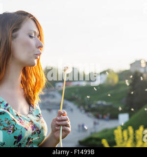 Mädchen bläst Löwenzahn Stockfoto