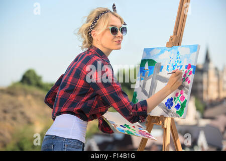 Schöne blonde Frau Künstler malt ein buntes Bild. Stockfoto