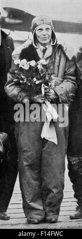 1920ER JAHRE JUNI 1928 AMELIA EARHART HOLDING ROSEN AM ENDE DES TRANSATLANTISCHEN FLUG TRAGEN SPRUNGANZUG PILOTEN LEDERMÜTZE Stockfoto