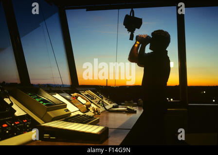 SILHOUETTE FLUGLOTSE IM KONTROLLTURM MIT FERNGLAS Stockfoto