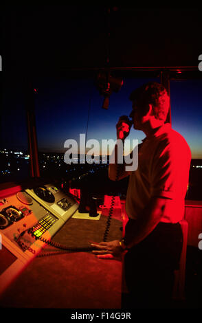 FLUGLOTSE IM KONTROLLTURM AUF HAND-HELD-RADIO Stockfoto