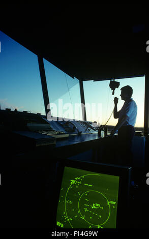 SILHOUETTE FLUGLOTSE IM KONTROLLTURM AUF HAND-HELD-RADIO Stockfoto