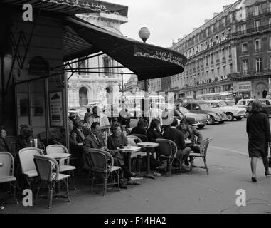 1960ER JAHRE GÄSTE IM CAFE DE LA PAIX SIDEWALK CAFE ECKE VON PARIS OPER HAUS IM HINTERGRUND PARIS FRANKREICH Stockfoto