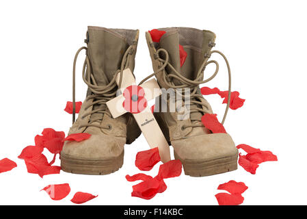 Paar der British Army desert Kampfstiefel auf einem weißen Hintergrund mit einem Kreuz und Mohn und Mohn Blütenblätter (künstliche). Stockfoto