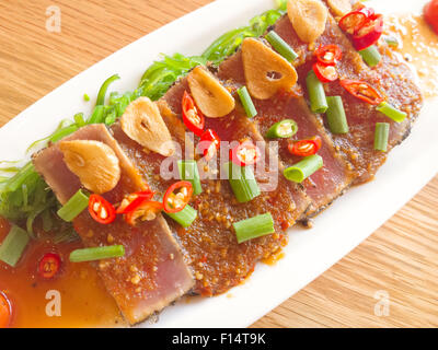 Thunfisch pikant mit Salat Fries auf Holztisch zu rauchen Stockfoto