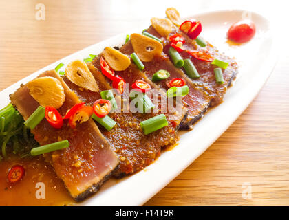 Thunfisch pikant mit Salat Fries auf Holztisch zu rauchen Stockfoto