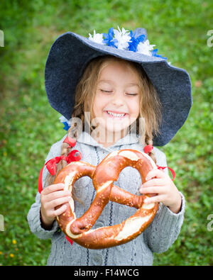 Nettes Mädchen mit bayerischen Hut und große Brezel. Selektiven Fokus Stockfoto