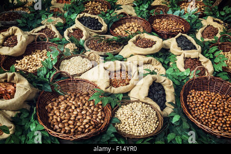 Bild von verschiedenen Arten von Nüssen in Wicker und Sackleinen-Schalen. Gesunde Ernährung. Stockfoto