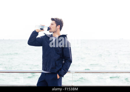 Porträt eines Mannes Sport im Kopfhörer Trinkwasser im freien Stockfoto