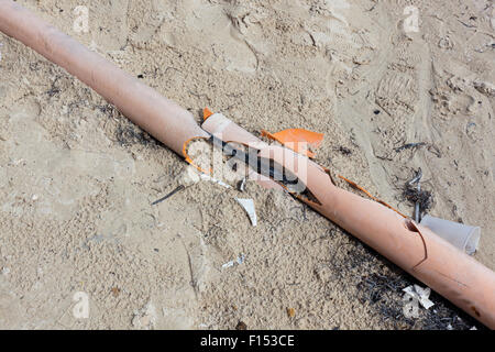 Ein Conduit-Rohr mit Adern durchzogen vom Strand Verkehr wurde aufgebrochen und ist umgeben von Wurf. Stockfoto