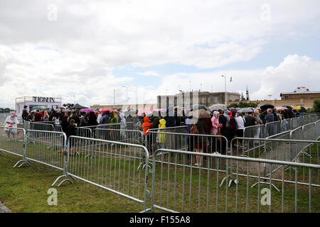 Weston-s-Mare, UK. 27. August 2015. Menschen, die Schlange für die Tickets für Eintritt in den Banksy Dismaland Fun Park in Weston-s-Mare bleiben in bester Laune. Trotz Regen und nur gesagt, es waren keine Plätze mehr verfügbar. Lokalen Royalist Terry Hutt machte seinen Weg durch die Massen unterhalten zu halten. Bildnachweis: Stephen Hyde/Alamy Live-Nachrichten Stockfoto