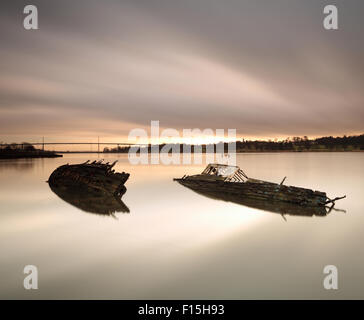 Schiffswracks von Bowling Harbour mit Erskine Bridge im Hintergrund bei Sonnenuntergang Stockfoto