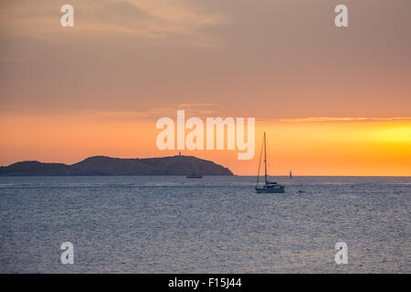 Sonnenuntergang mit einem Segelboot über Mittelmeer Wasser in Ibiza, Spanien. Stockfoto