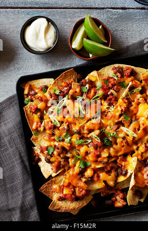 Chili Nachos überbacken mit Käse auf Backblech, Studio gedreht auf grauem Hintergrund Stockfoto