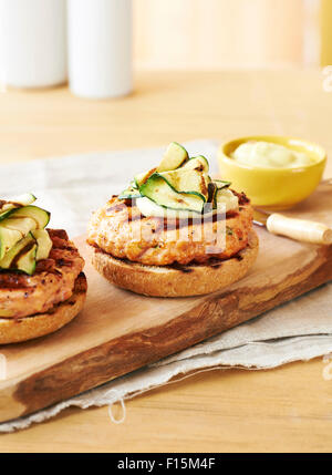 Gegrillt, offenen Lachs Burger mit Aioli und Zucchini auf Holzbrett, Studio gedreht Stockfoto