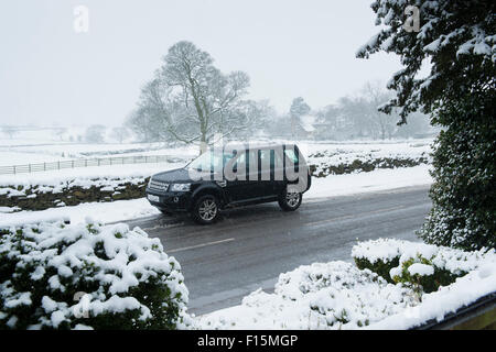 Schneit & einen Land Rover Freelander 2, Allrad-Fahrzeug (4 x 4) parkt auf einer verschneiten Landschaft Straße im Winter - Yorkshire, England, UK. Stockfoto