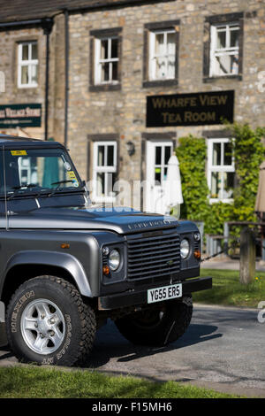Vorderseite des sauber, glänzend, grau, Land Rover Defender (ikonische, robuste 4 x 4 Fahrzeug) geparkt in sonniger Lage auf einem Yorkshire Dales Road - Burnsall, England, UK. Stockfoto