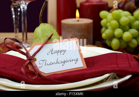 Happy Thanksgiving Tischdekoration in den klassischen rustikalen Farben auf Holztisch mit Füllhorn Herzstück, Kerzen und Obst. Stockfoto