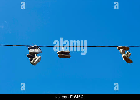 Schuhe aus einem elektrischen Draht hängen Stockfoto
