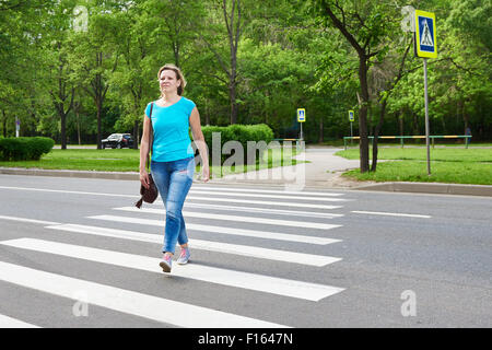 Junge Frau beim Überqueren der Straße Stockfoto