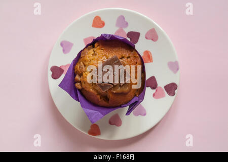 Sainsburys den Unterschied schmecken gesalzen Karamell muffin auf Herz Platte isoliert auf rosa Hintergrund Stockfoto