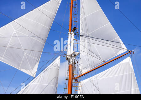 Mast und weiße Segel Segelboot gegen den blauen Himmel Stockfoto