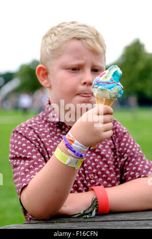 Sechs Jahre alten Jungen Lippen zu lecken, während des Essens ein Eis Kornett mit zusätzlichen Aromen Stockfoto