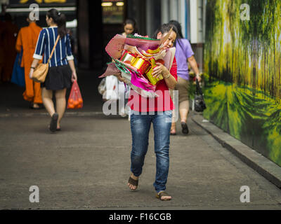 Bangkok, Bangkok, Thailand. 28. August 2015. Eine Frau geht in Wat Mangkon Kamalawat im Abschnitt Chinatown von Bangkok mit Angeboten an Hungry Ghost Tag verbrannt werden. Wat Mangkon Kamalawat ist der größte Mahayana buddhistische Tempel in Chinatown. Mahayana-Buddhisten glauben, dass die Pforten der Hölle werden auf den Vollmond des siebten Mondmonats des chinesischen Kalenders geöffnet, und die Geister der hungrigen Geister die Erde durchstreifen durfte. Diese Geister müssen essen und Verdienst zurecht zu finden zurück zu ihren eigenen. Menschen helfen, indem Nahrung, Papiergeld, Kerzen, Blumen, Herstellung in eigenen Verdienst Stockfoto