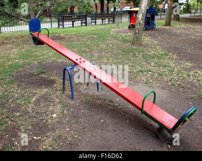 Wippen Sie roten Farbe auf dem Spielplatz Closeup Diagonale Bild. Auf dem Spielplatz gibt es niemanden. Stockfoto