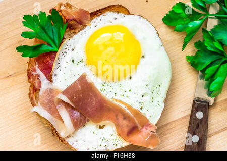 Sandwich mit einem Spiegelei und Speck auf der Tischplatte-Ansicht Stockfoto