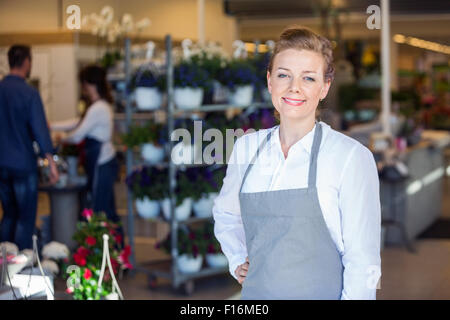 Portrait von Lächelnd weibliche Verkäufer in Flower Shop Stockfoto