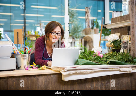 Mit Laptop im Blumenladen Blumengeschäft Stockfoto