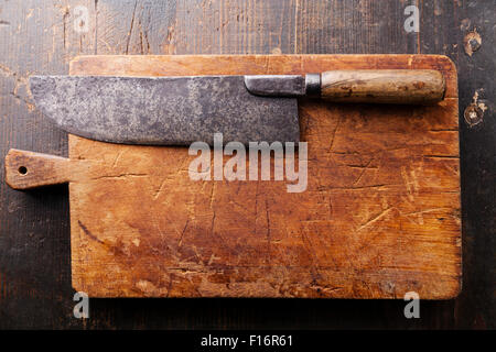 Schneidebrett und Fleischerbeil auf dunklem Holz Stockfoto