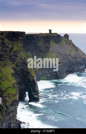 Ansicht des Turms bei Hag es Head und Meer Arch am Abend an den Klippen von Moher an der Küste von Clare im Westen von Irland Stockfoto