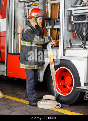 Feuerwehrmann Anpassung Schlauch In LKW Stockfoto