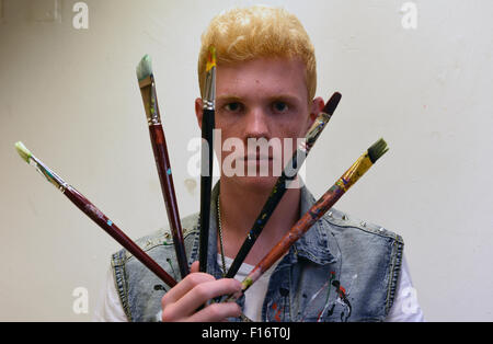 Dpa-exklusiv? Künstlers Leon Loewentraut posiert mit Pinsel bei einem Fotoshooting in seinem kleinen Studio in Düsseldorf, Deutschland, 20. August 2015. Die 17 Jahre alte Schüler aus Kaarst, in der Nähe von Düsseldorf, ist der neue Star der Kunstszene. Foto: Horst Ossinger/dpa Stockfoto