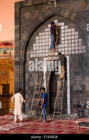 Indien, Jammu & Kaschmir, Srinagar, Nowhatta, Jamia Masjid, Interieur, Arbeiter Wiederherstellung der koranischen Inschriften Stockfoto