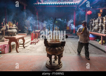 Ha Chuong Hoi Quan Tempel, ein Besucher der Ha Chuong Hoi Quan Pagode in Cholon, Saigon, trägt ein Bündel rauchen Räucherstäbchen, Vietnam Stockfoto