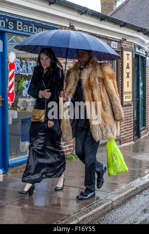 Junge Opernfreunde kommen im strömenden Regen bei Lewes Station auf dem Weg nach Glyndebourne Opera House, Lewes, Sussex, Großbritannien Stockfoto
